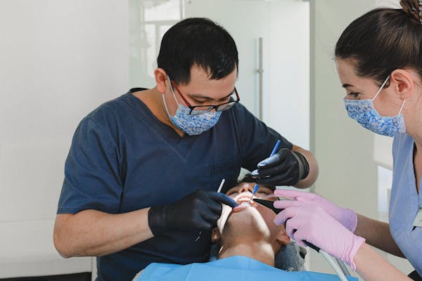 dentist and assistant doing dental work on a patient