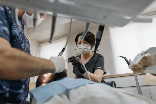 Dentist and his assistant doing dental work with patient