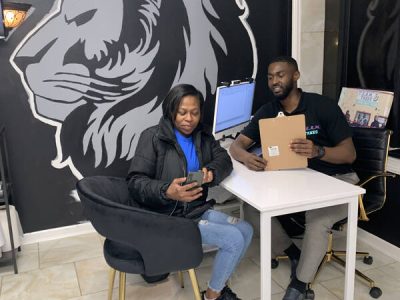 Two people in an office sitting on a chair